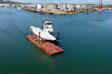 Barge with cradle with sloop towed to Oakland